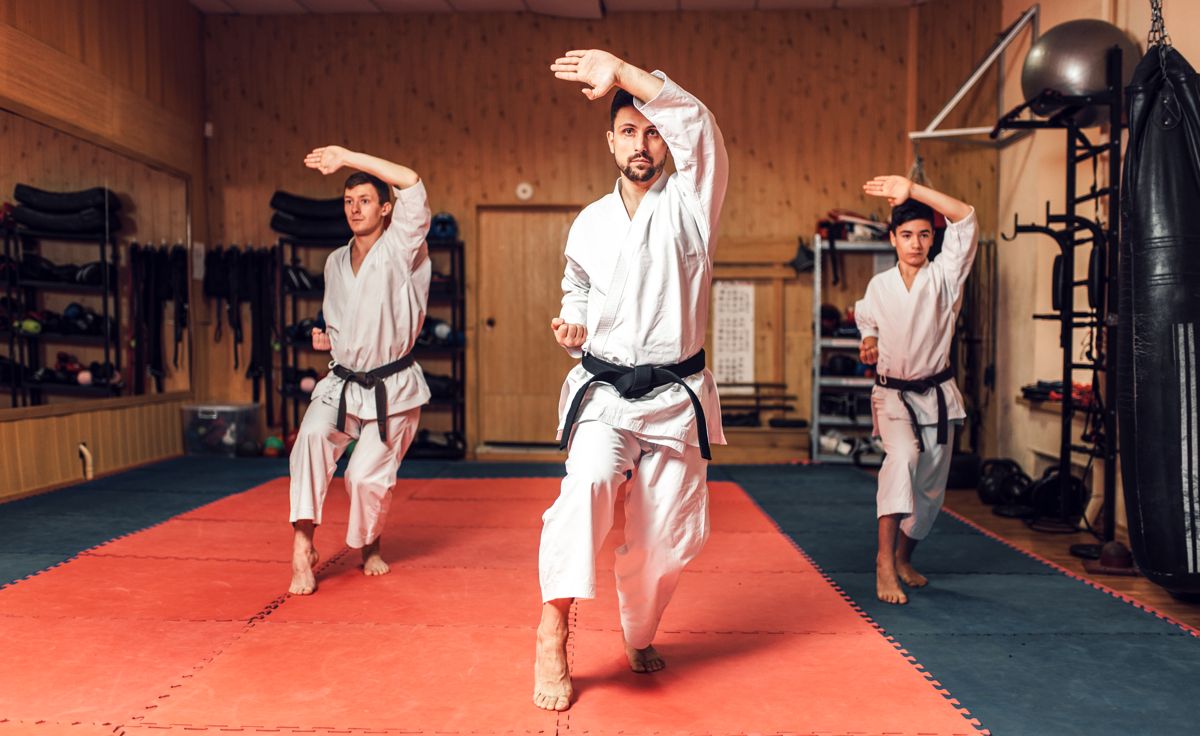 trzech zawodników karate na sali ćwiczeń